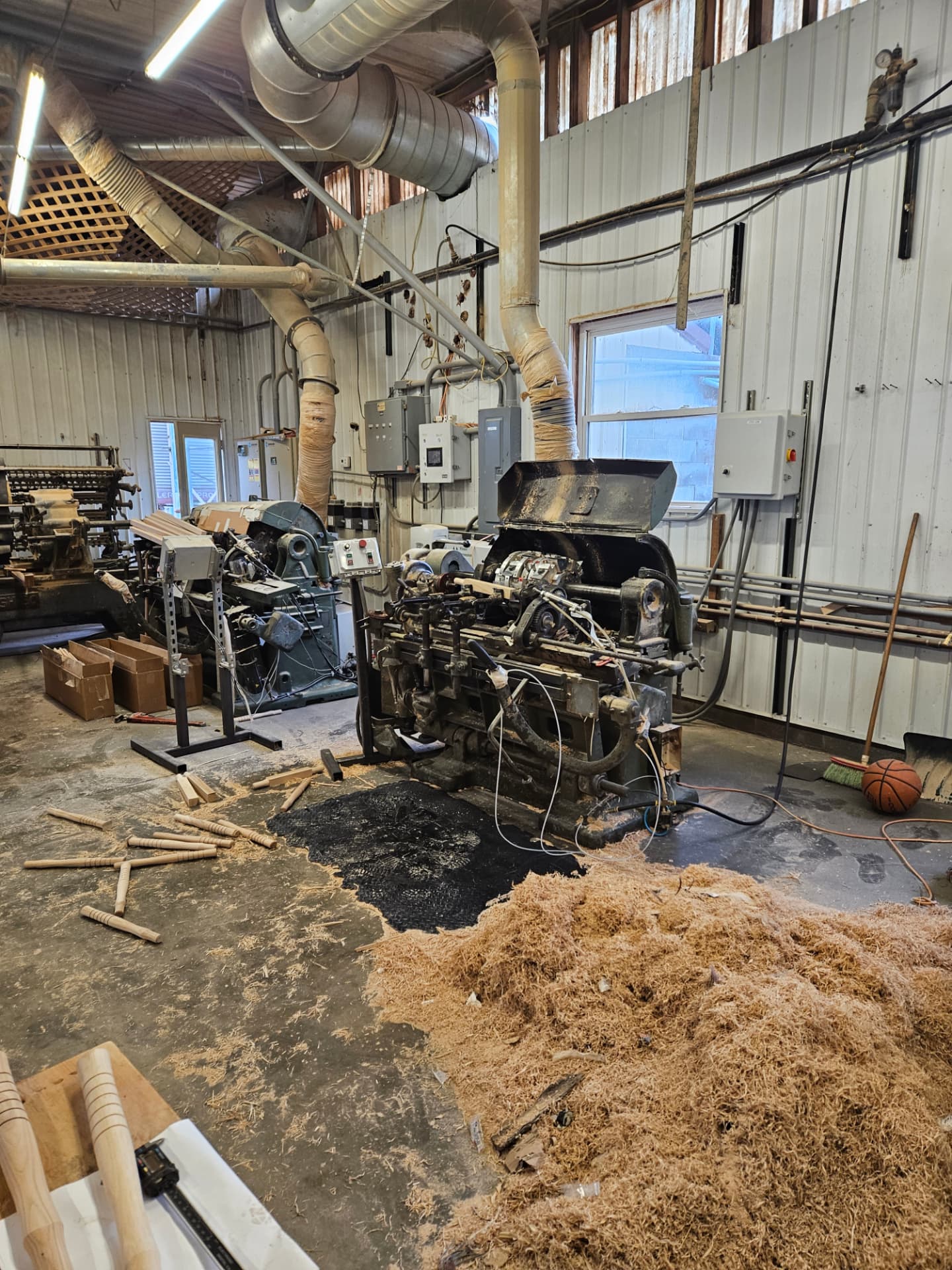 Pro-Drive Fasteners®'s in-house handle-turning shop — lathes and hickory handle blanks surrounded by wood shavings, where every mallet handle is turned